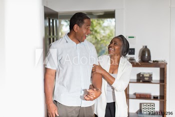 Happy senior couple holding hands at home