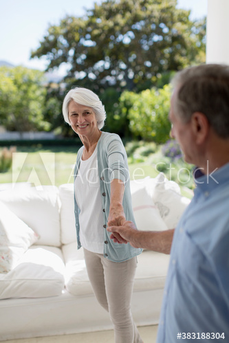 Happy senior couple holding hands on patio