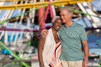Happy senior couple hugging at sunny amusement park
