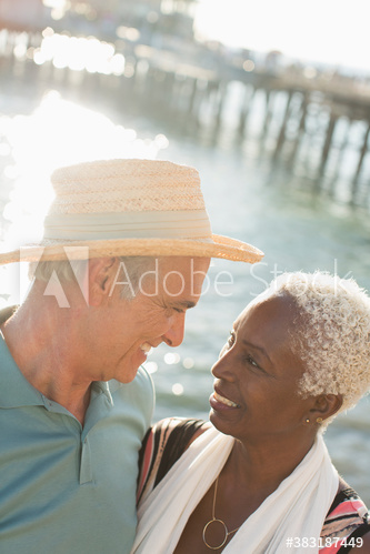 Happy senior couple on sunny ocean pier