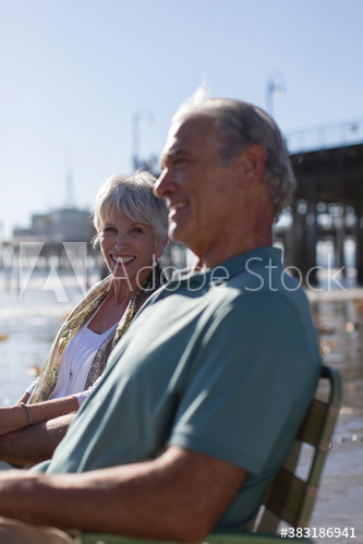 Happy senior couple relaxing on sunny beach