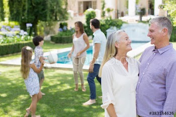 Happy senior couple with family in backyard