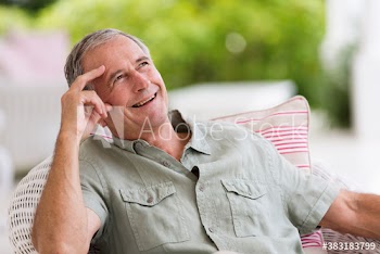Happy senior man looking up on patio