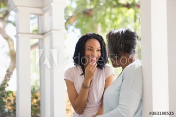 Happy senior mother and adult daughter on porch