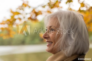 Happy senior woman in autumn park
