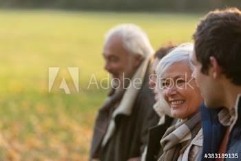 Happy senior woman in autumn park with family