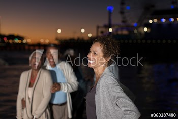 Happy senior woman on beach with friends at night