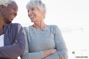 Happy senior women friends with arms crossed