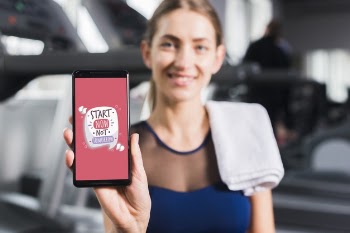 Happy sporty woman presenting smartphone mockup Free Psd