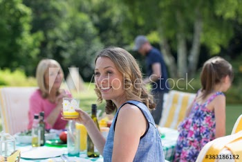 Happy woman enjoying lunch on patio with family