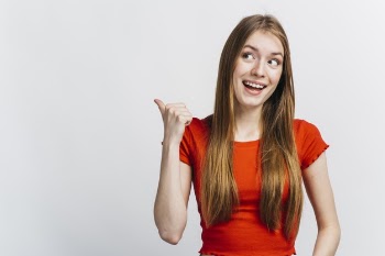 Happy woman pointing behind her Free Photo