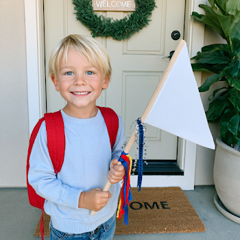 Happy Young Boy Holding Blank Flag on Porch