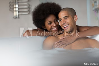 Happy young couple enjoying bubble bath