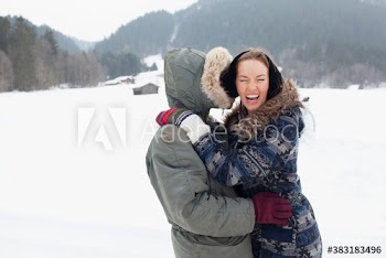 Happy young couple hugging in snowy field