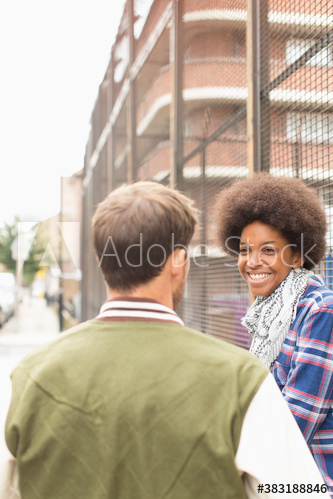 Happy young couple on city sidewalk