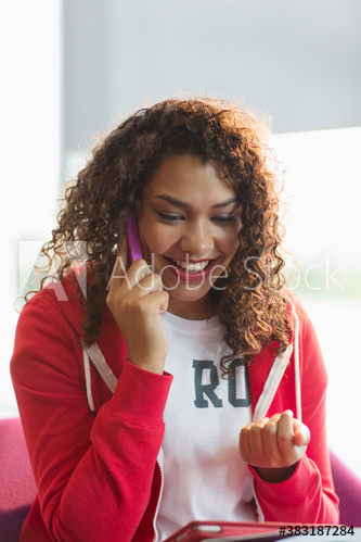 Happy young female college student talking on smart phone