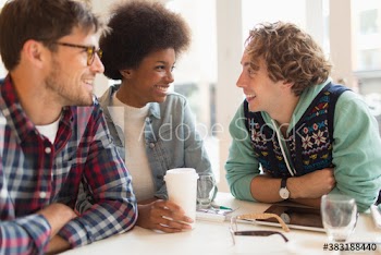 Happy young friends drinking coffee in cafe