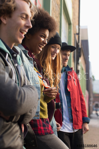 Happy young friends hanging out on sidewalk