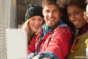 Happy young friends taking selfie with smart phone