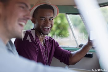 Happy young male friends with smart phone in van