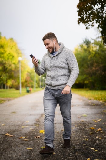 Happy young man walking through the park Free Photo