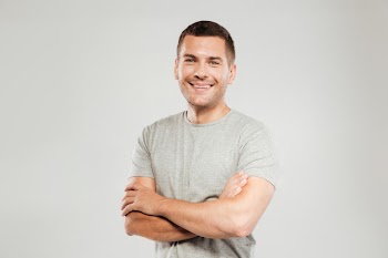 Happy young man with arms crossed. Free Photo