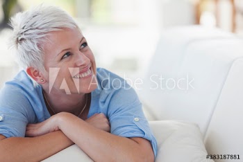 Happy young woman laying on sofa