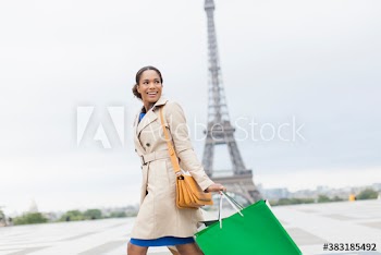 Happy young woman with shopping bags passing Eiffel Tower, Paris