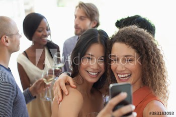 Happy young women friends taking selfie at party