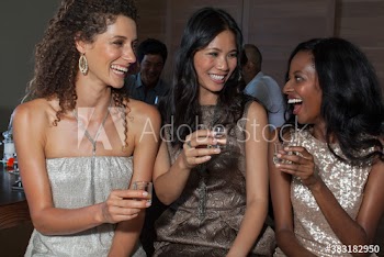 Happy young women friends taking tequila shots at party
