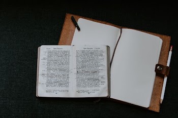 hardbound book on top of brown binder