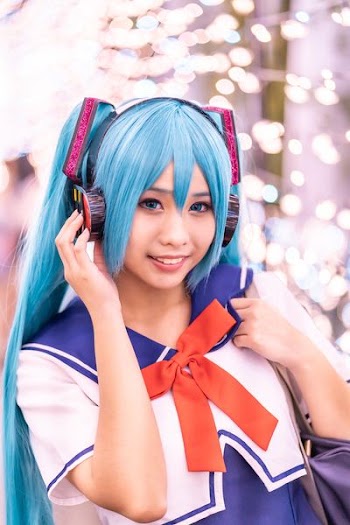 Hatsune Miku smiling holding headphones