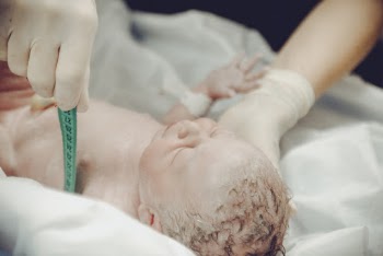Health Personnel Measuring a Newborn Baby