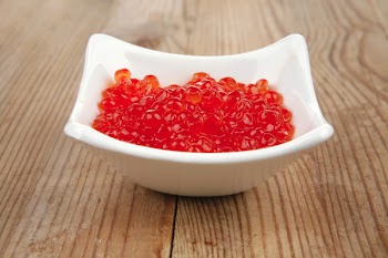 healthy food : red salmon caviar canape over wooden table in small white bowl