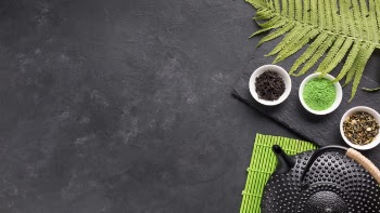 Healthy tea ingredient with black teapot and fern leaves over backdrop Free Photo