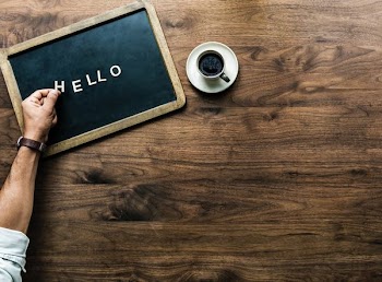 Hello text on chalk board beside white coffee cup