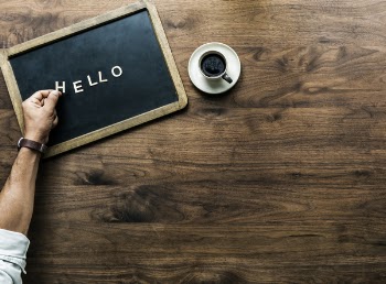 Hello Text on Mini Chalkboard Beside Cup of Coffee 