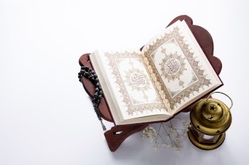High angle opened quran next to candle Free Photo