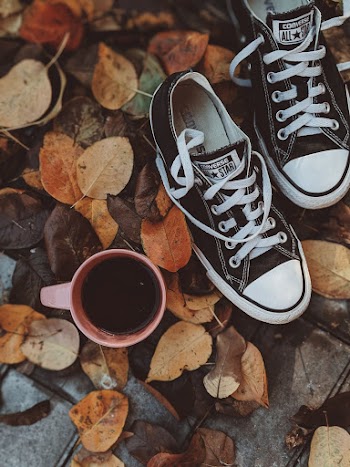High Angle Photo of Converse All Star Sneakers Near Cup of Coffee