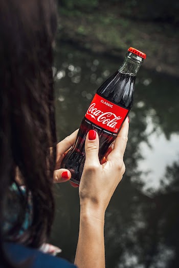 High-Angle Photo of Person Holding a Coca-cola Bottle