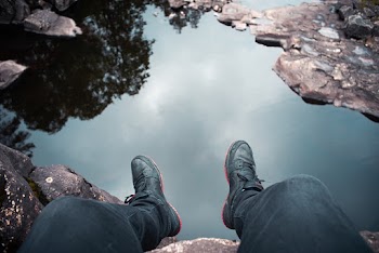 High-Angle Photo of Person Sitting on Cliff