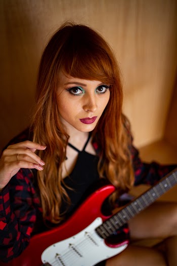 High-Angle Photo of Woman Holding Electric Guitar