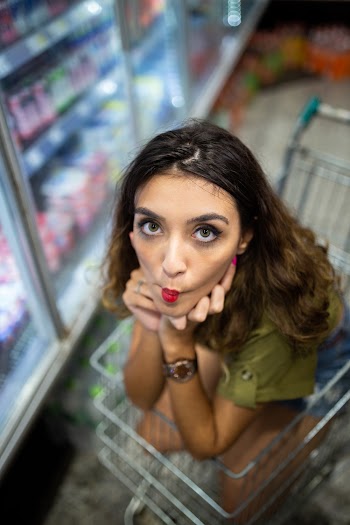 High Angle Photo of Woman Sitting in Shopping Cart