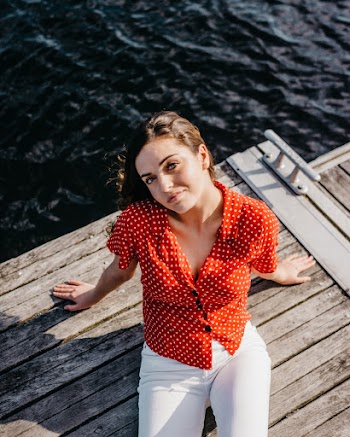 High Angle Photo of Woman Sitting on Dock