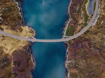 high angle photography of concrete road connecting two lands