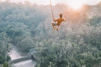 high angle photography of man sitting on swing