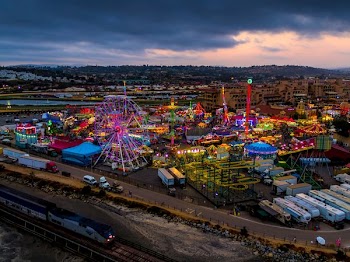 high-angle photography of multicolored amusement park beside train during daytime