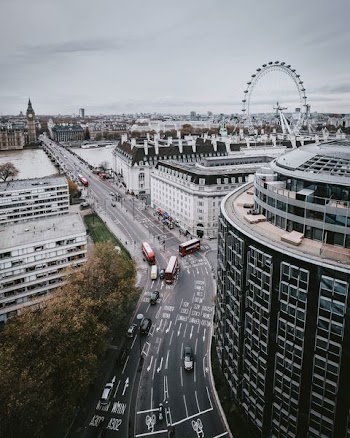 high angle photography of vehicles passing on street surrounded with city buildings