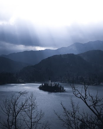 High Angle Shot Of A Church on Islet Surrounded By Beautiful Mountainous Landscape