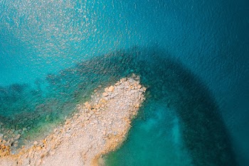 High Angle Shot of Rocks on Body of Water